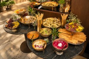 Spread of healthy, colourful dishes and salads served on a dark stone table at Avās Wellness